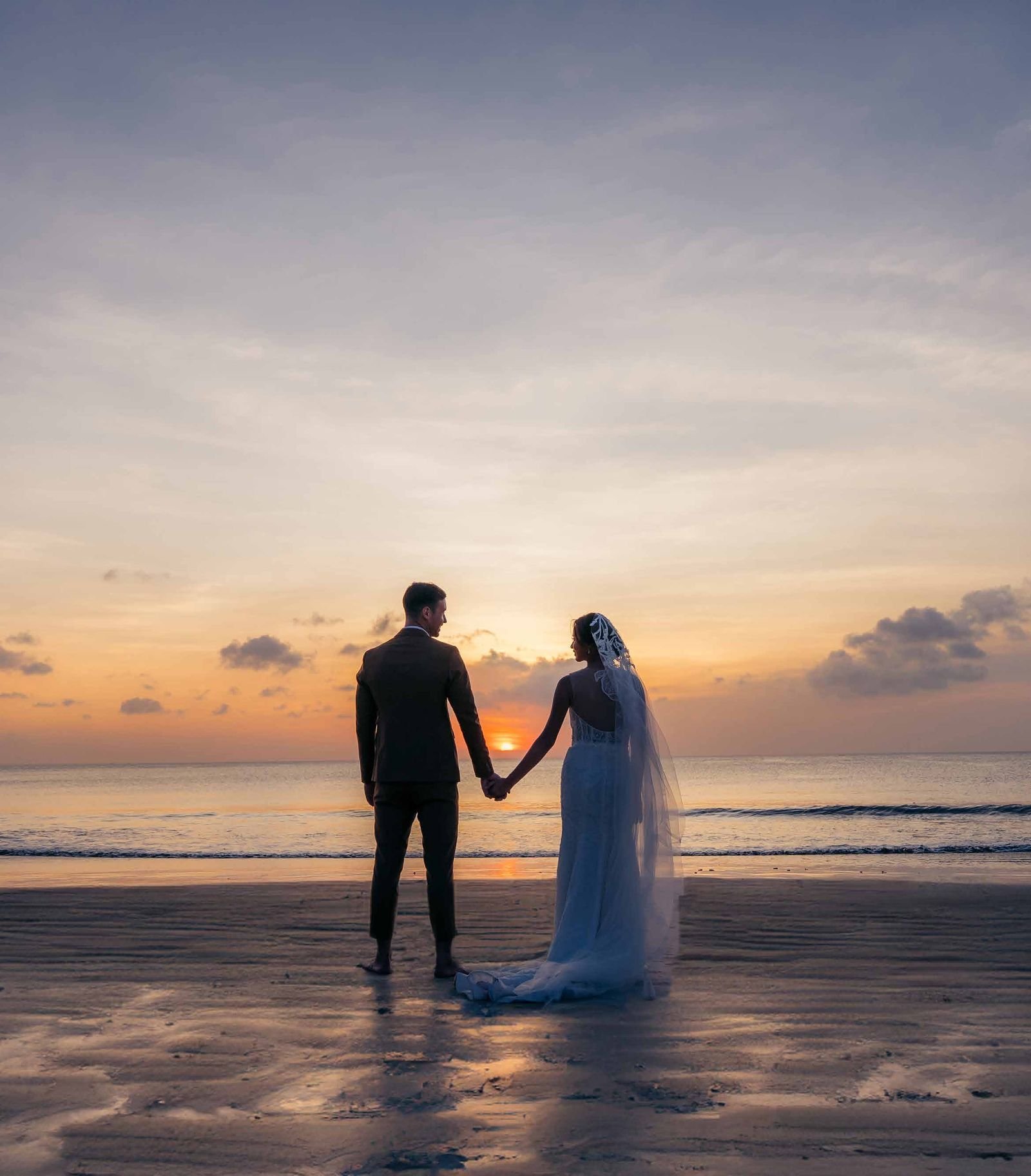 Couple silhouetted against the Jimbaran Bay sunset
